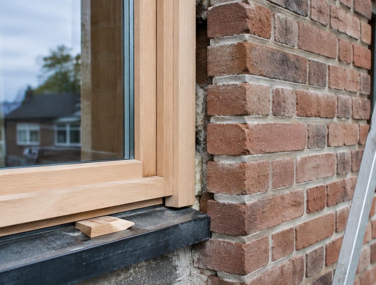 Nieuw houten kozijn in een bakstenen gevel